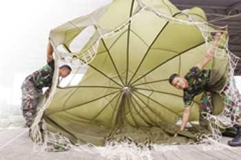 prajurit Paskhas 462 Pulanggeni tampak sibuk melipat parasut di Hanggar Charlie