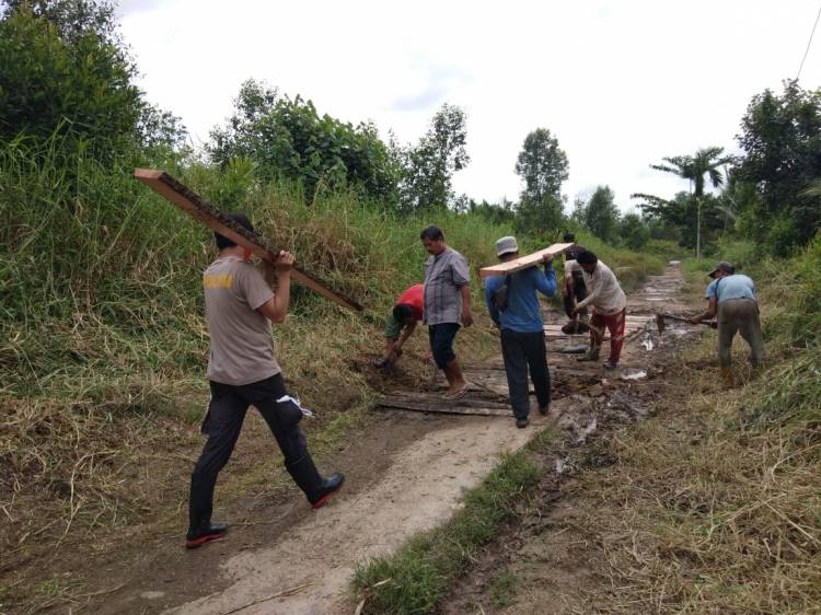 Bhabinkamtibmas Desa Sungai Terab dan Warga Desa Tanjung Labuh Goro Perbaiki Jalan Lintas Desa